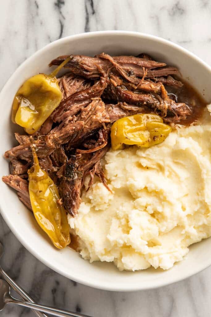 Mississippi pot roast in a bowl with mashed potatoes.