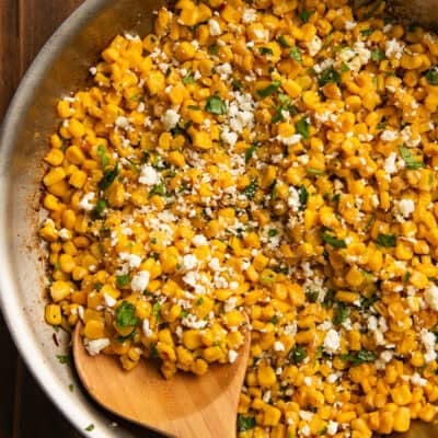 Cilantro lime corn in a skillet with a spoon in it