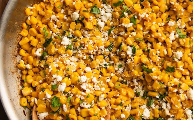 Cilantro lime corn in a skillet with a spoon in it