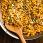 Cilantro lime corn in a skillet with a spoon in it